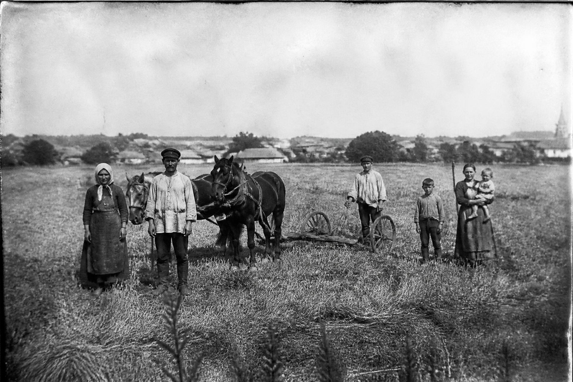 Archival photograph of rural field workers with horses and a wooden plough
